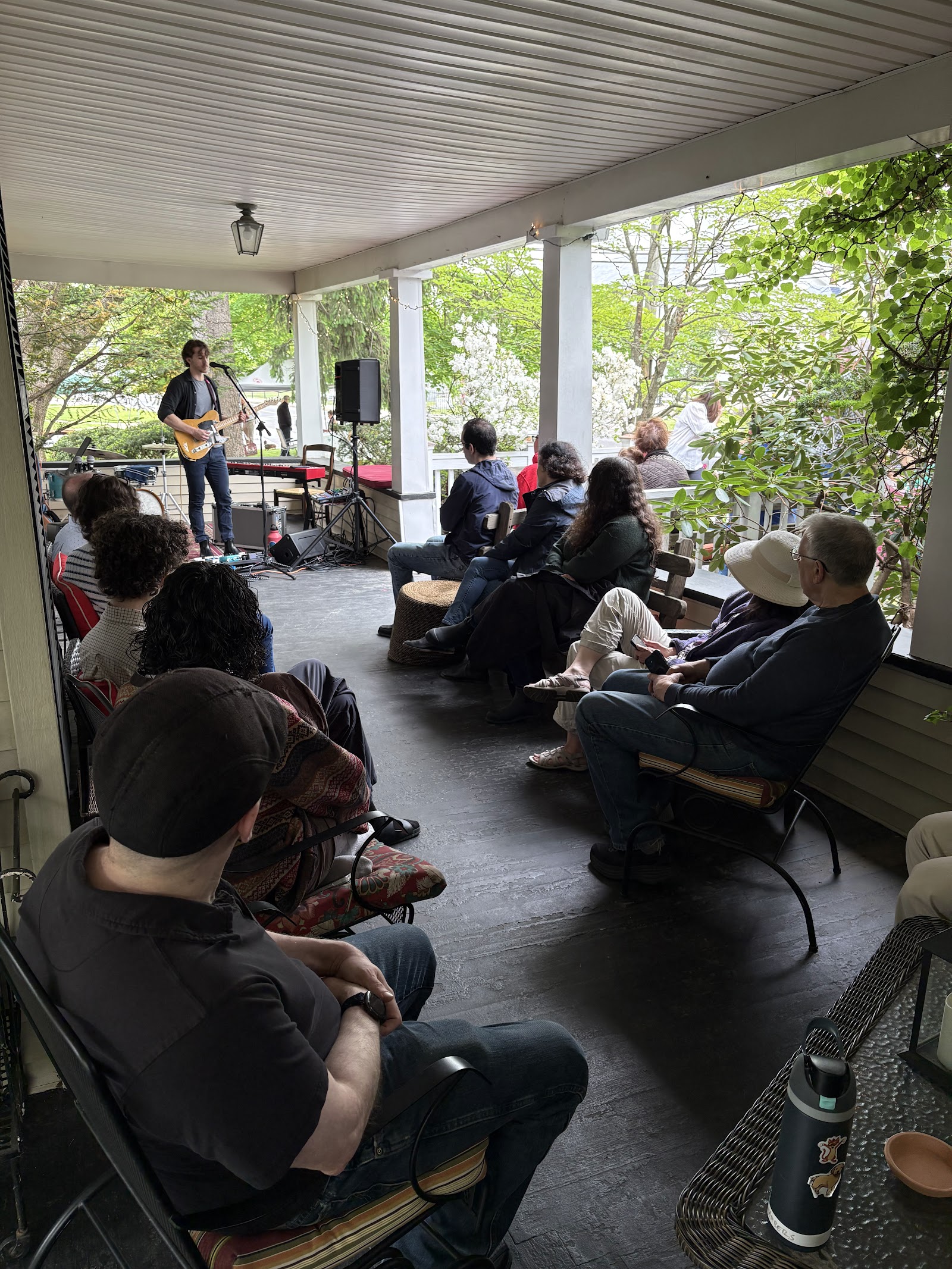 A porch full of neighbors enjoying live guitar at Dutch Neck Porchfest